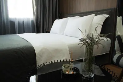 a bedroom with a bed with a vase of flowers on a table at Urban Nest Nis in Niš