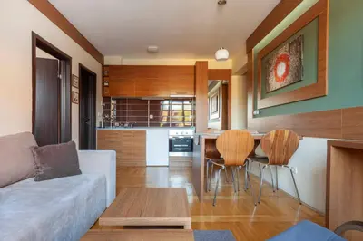 a living room with a couch and a table and chairs at HostGost at Kraljevi Čardaci in Kopaonik