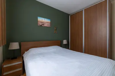 a bedroom with a white bed and green walls at HostGost at Kraljevi Čardaci in Kopaonik