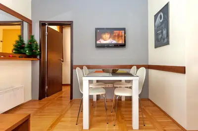 a dining room with a white table and white chairs at HostGost at Kraljevi Čardaci in Kopaonik