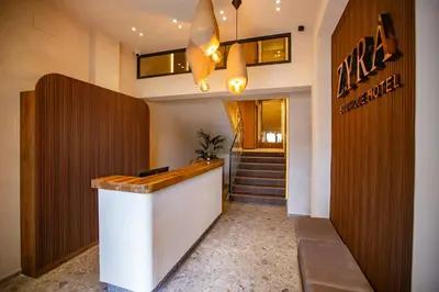 a lobby of a hotel with a counter and stairs at Zyra boutique hotel in Leskovac