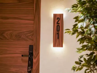 a wooden door number hanging on a wall at Zyra boutique hotel in Leskovac