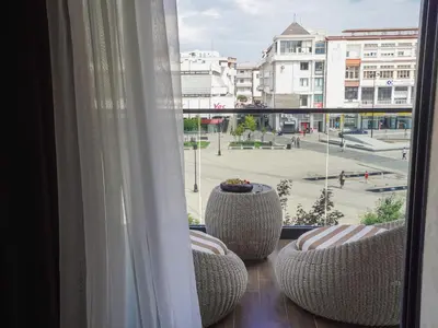 a balcony with chairs and a view of a city at Zyra boutique hotel in Leskovac