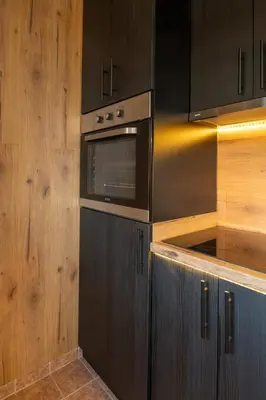a kitchen with black cabinets and a microwave at Ryo Golden Imperial 1 in Kruševac