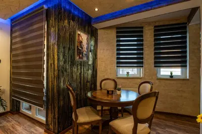 a dining room with a table and chairs and windows at Ryo Golden Imperial 1 in Kruševac