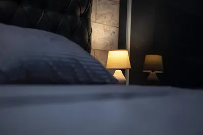 a bedroom with a bed with a lamp next to it at Ryo Golden Imperial 1 in Kruševac