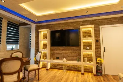 a living room with a tv on a brick wall at Ryo Golden Imperial 1 in Kruševac