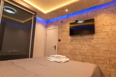 a room with a bed with a television on a wall at Ryo Golden Imperial 1 in Kruševac