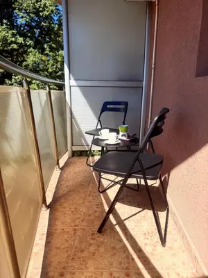 two chairs and a table on a balcony at Natalie Apartment in Niš