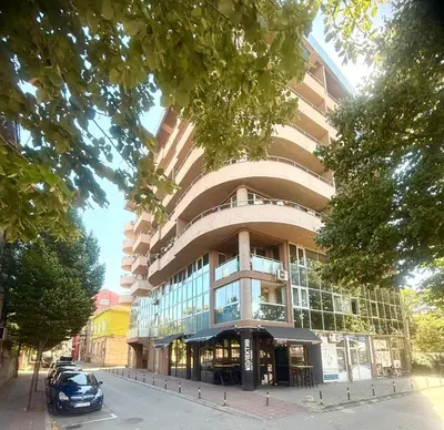 a building with a car parked in front of it at Natalie Apartment in Niš