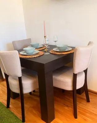 a dining room table with two chairs and a black table at Natalie Apartment in Niš