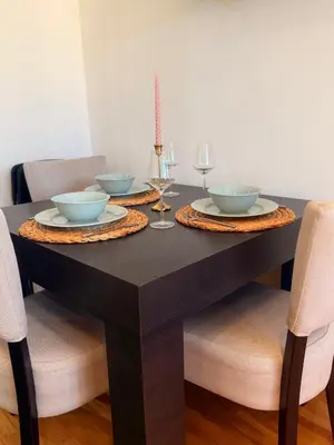 a dining room table with bowls and wine glasses on it at Natalie Apartment in Niš