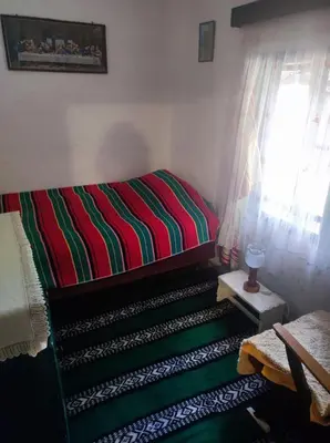 a bedroom with a bed with a colorful striped blanket at Konak Anja