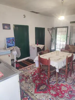 a living room with a table and chairs and a kitchen at Konak Anja