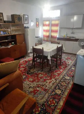 a living room with a table and chairs on a rug at Konak Anja