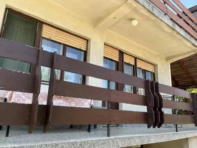 a wooden bench in front of a house at Apartman Jelena in Soko Banja