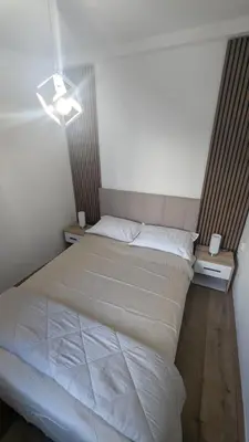 a bedroom with a white bed with two night stands at Central House Niš in Niš