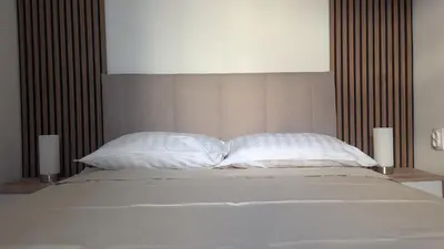 a bed with two white pillows and two candles at Central House Niš in Niš
