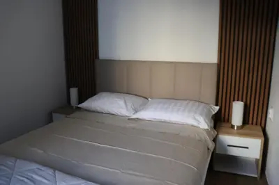 a bedroom with a bed with two night stands and two lamps at Central House Niš in Niš