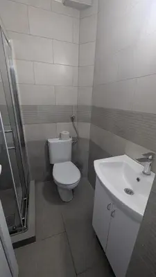 a bathroom with a white toilet and a sink at Central House Niš in Niš