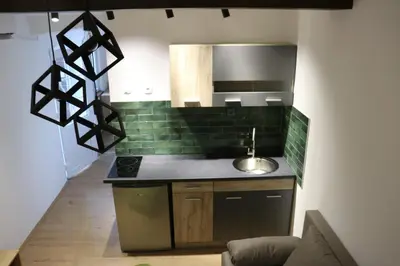 a kitchen with green tiles on the wall and a sink at Central House Niš in Niš