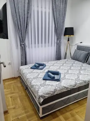 a bedroom with a bed with blue towels on it at Apartman Centar LUX in Vrnjačka Banja