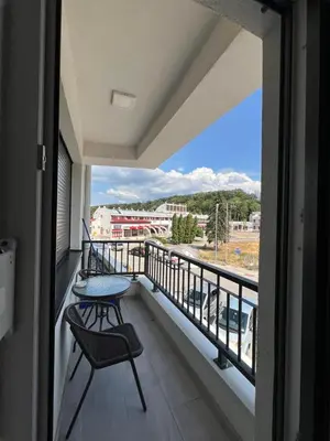 a balcony with a table and a chair and a view at Apartman Centar LUX in Vrnjačka Banja