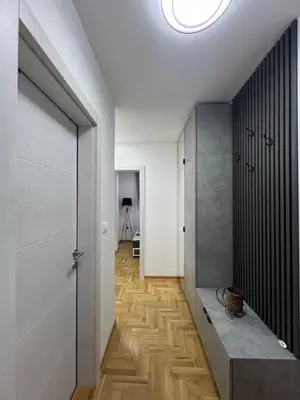 a room with a hallway with a table and a door at Apartman Centar LUX in Vrnjačka Banja
