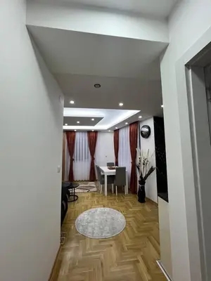 a hallway with a table and a dining room at Apartman Centar LUX in Vrnjačka Banja