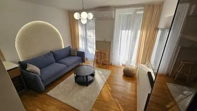 a living room with a blue couch and a table at Sila apartman Vrnjačka Banja in Vrnjačka Banja