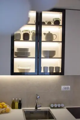 a kitchen sink with an open cabinet with dishes in it at Sila apartman Vrnjačka Banja in Vrnjačka Banja