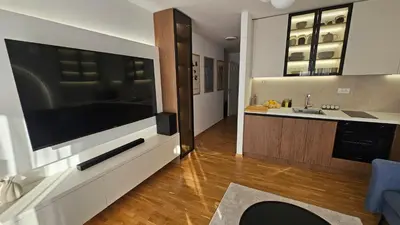 a living room with a large flat screen tv on a wall at Sila apartman Vrnjačka Banja in Vrnjačka Banja