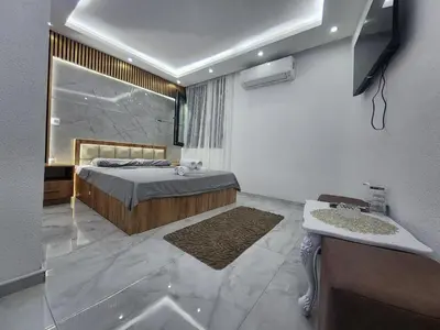 a bedroom with a bed and a sink and a mirror at Vila Bosanski Merak in Bujanovac