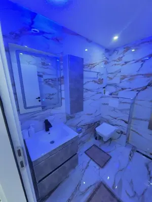 a white bathroom with a sink and a toilet at Vila Bosanski Merak in Bujanovac