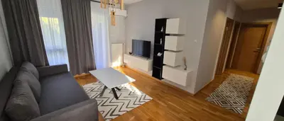 a living room with a couch and a tv at 15th Corner Apartment in Niš