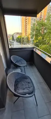 a balcony with two chairs and a window at 15th Corner Apartment in Niš