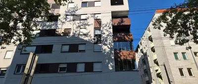 a tall building with its shadow on the side of it at 15th Corner Apartment in Niš