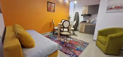 a living room with a couch and a table at Apartmani Pejovic in Niš