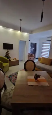 a living room with a table and a couch at Apartmani Pejovic in Niš