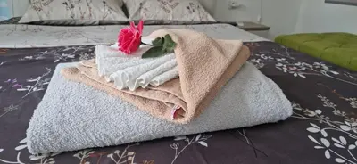a pile of towels sitting on top of a bed at Apartmani Pejovic in Niš