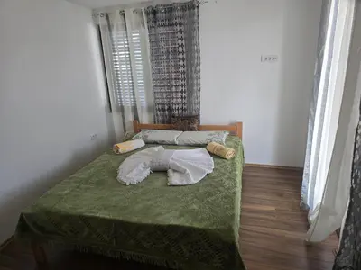 a bedroom with a bed with a green comforter at Zuto brdo Batinac