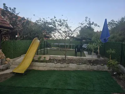 a playground with a yellow slide in a yard at Zuto brdo Batinac