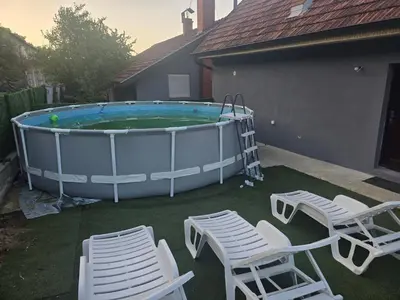 a pool with a bunch of chairs and a table at Zuto brdo Batinac