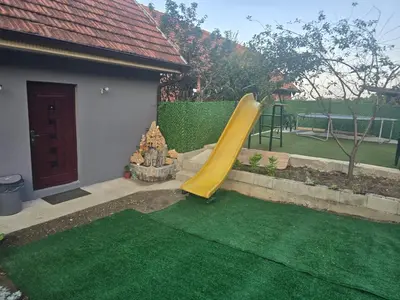 a playground with a slide in a yard at Zuto brdo Batinac