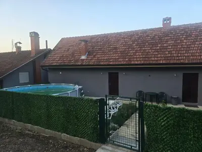 a house with a swimming pool and a fence at Zuto brdo Batinac