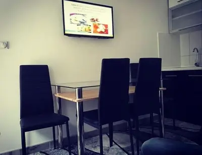 a table and chairs in a kitchen with a picture on the wall at Apartman Smilic Lukovska banja in Lukovo