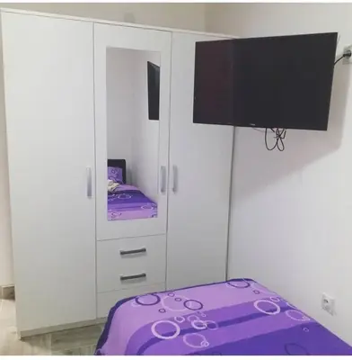 a white cabinet with a purple bed in a room at Apartman Smilic Lukovska banja in Lukovo