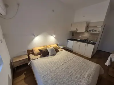 a small bedroom with a bed and a kitchen at Oaza studio 1 in Soko Banja