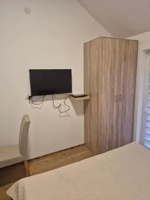 a bedroom with a bed and a cabinet with a television at Oaza studio 1 in Soko Banja