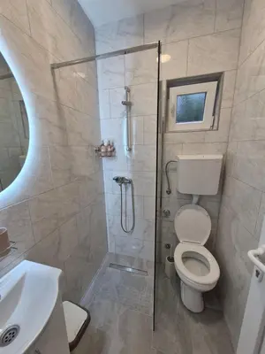 a bathroom with a shower with a toilet and a sink at Oaza studio 1 in Soko Banja